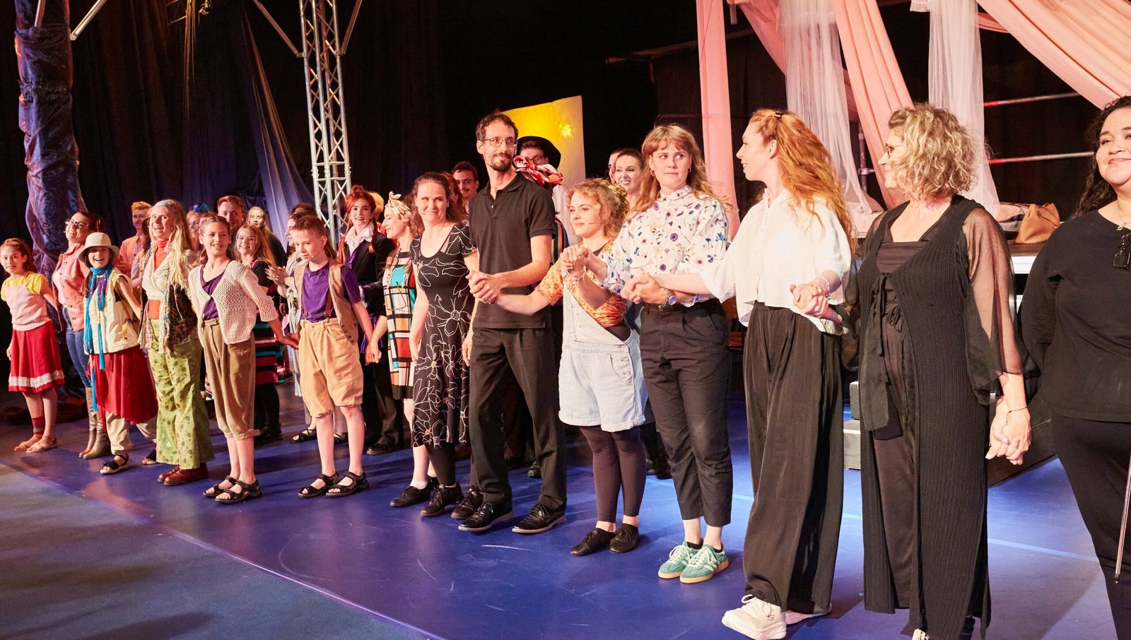 CS5A8313 Drei Journalisten, zwei im Vordergrund mit Westen und Hemden, der Praktikant im Hintergrund mit schwarzer Kleidung und vielen Taschen und Koffern